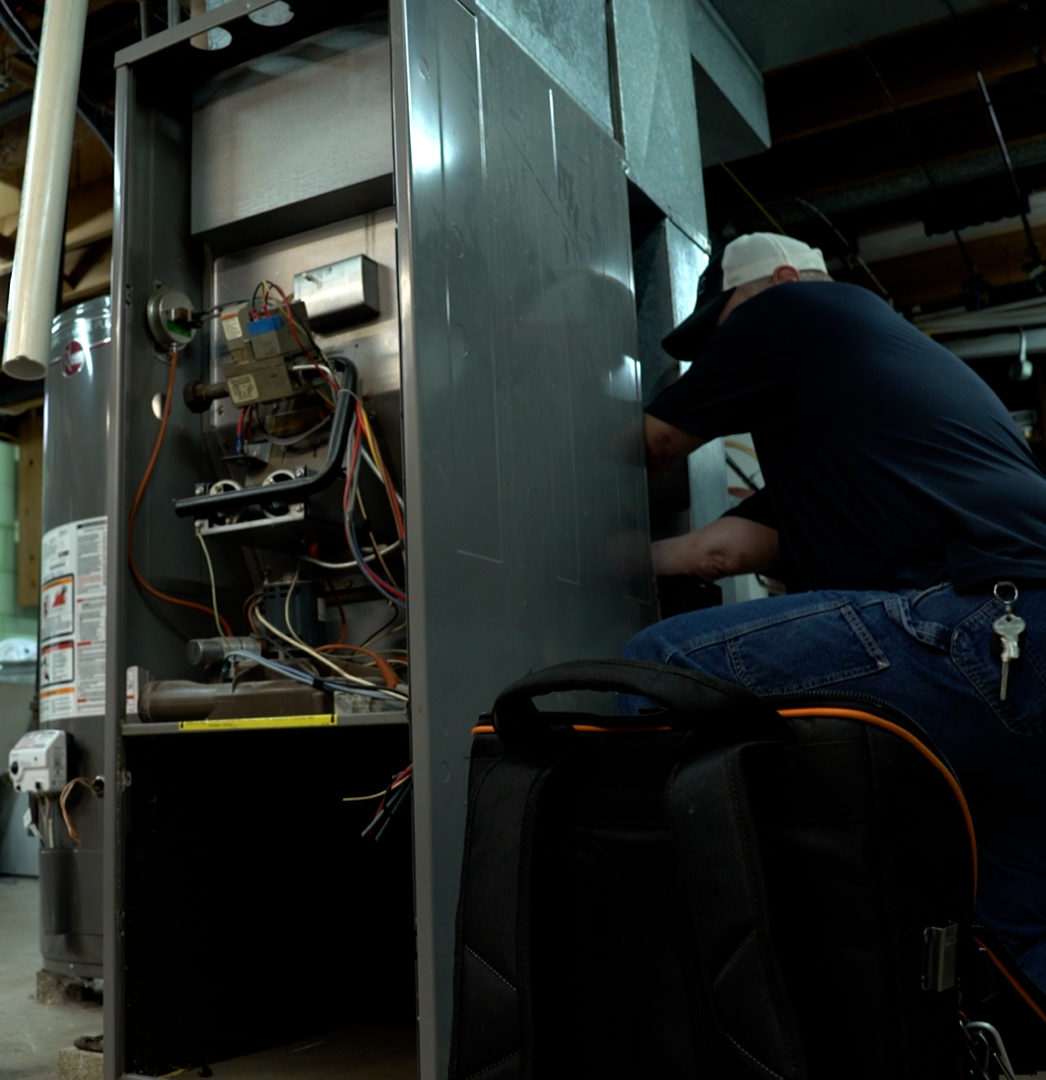 A Hometown Heating, Air & Electric technician performing a furnace replacement in a resident's home